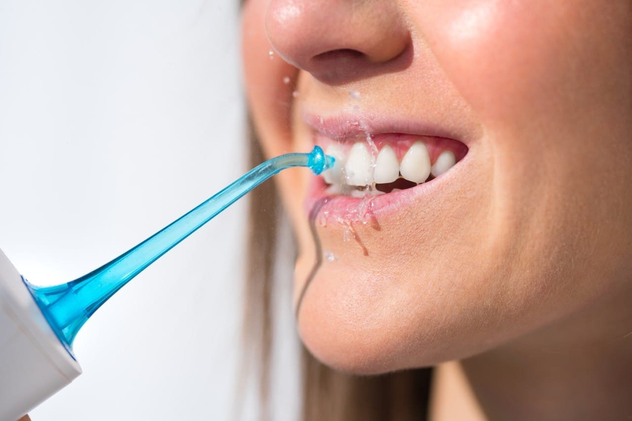 woman using the waterpik water flosser Creekside Dental