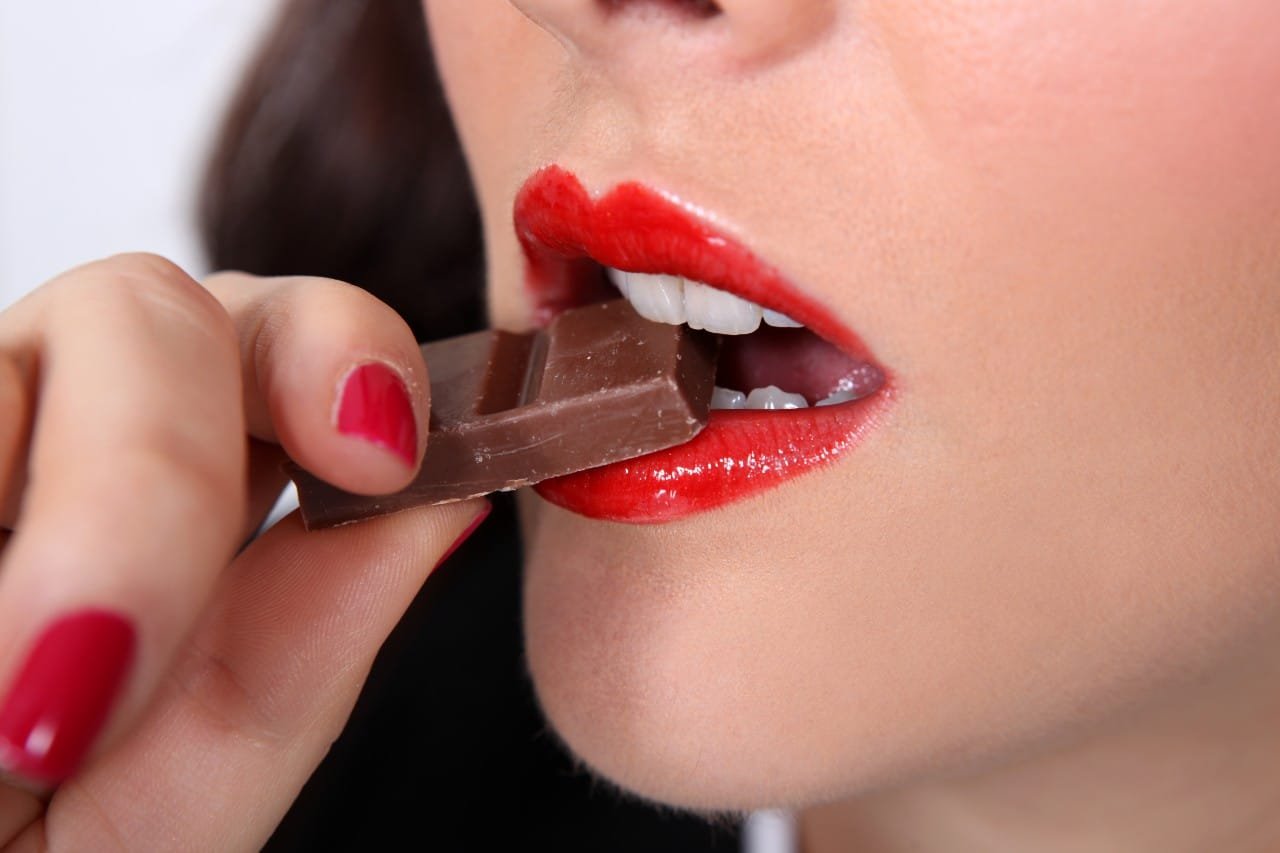 woman eating chocolate beat sugar addiction Creekside Dental