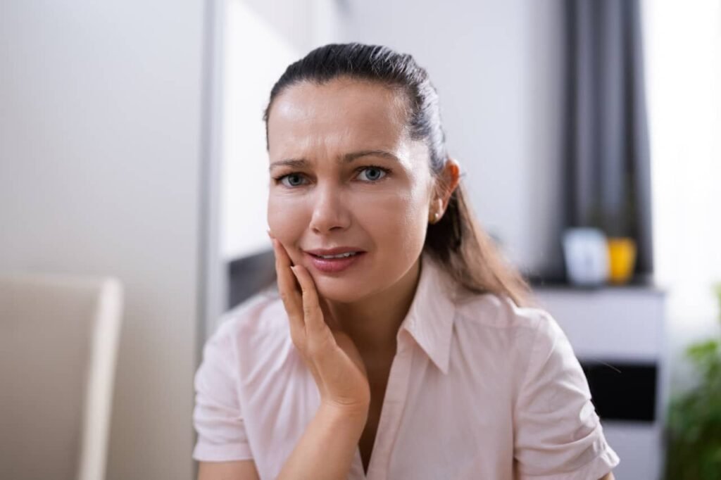 woman touching her cheeks because of tooth decay Creekside Dental