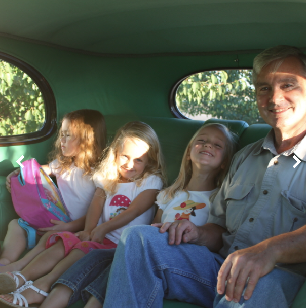 Dr. Packard inside an antique car Creekside Dental